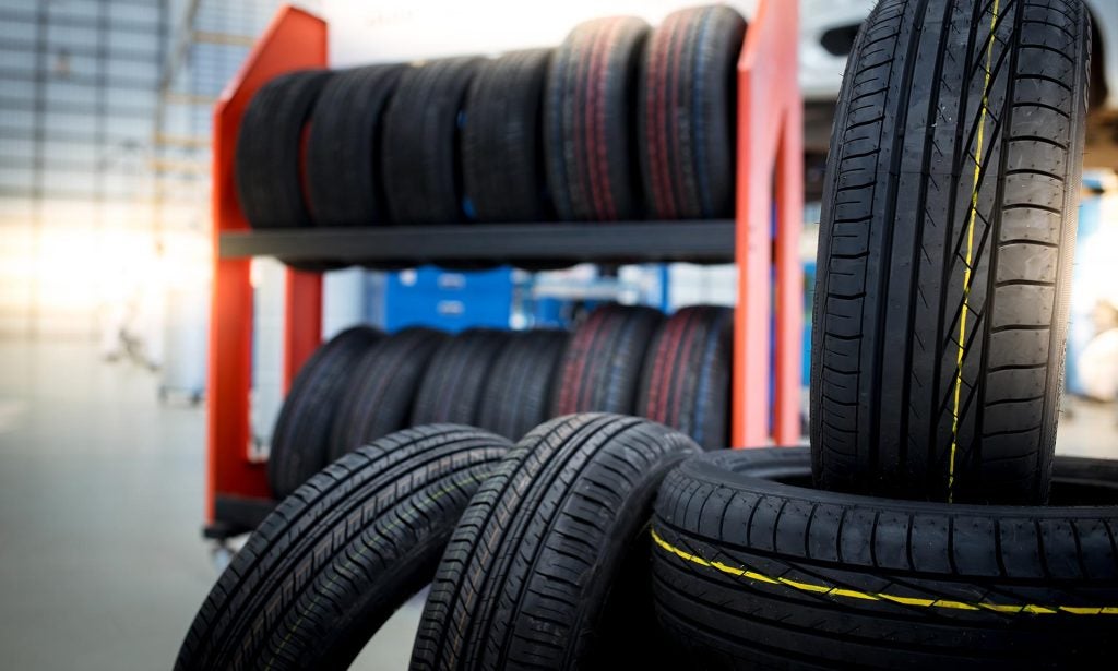New car tires displayed on red racks in a bright garage workshop