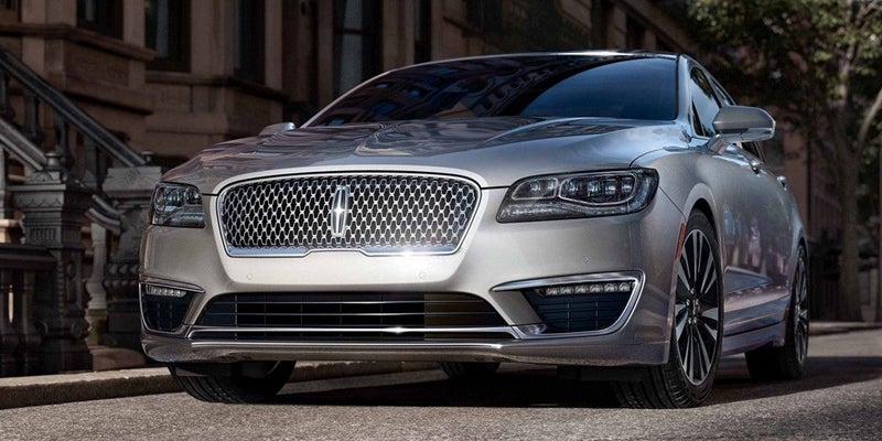 Front view of a silver Lincoln MKZ parked on a city street.