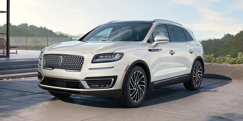 White Lincoln Nautilus SUV parked on a modern stone patio outdoors.
