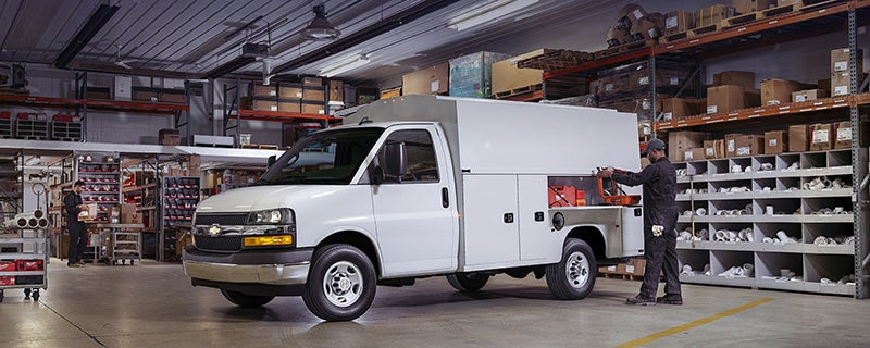 Chevrolet service van inside a workshop with a technician.