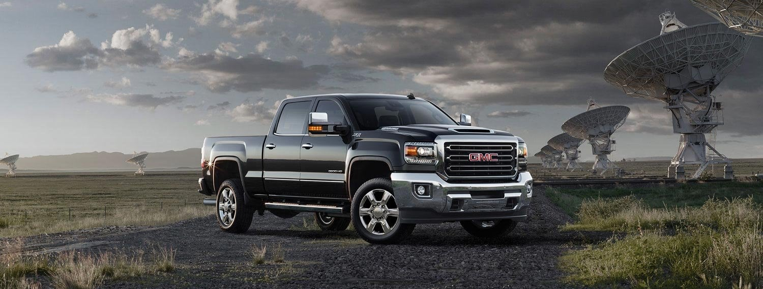 Front 3/4 view of a black 2024 GMC Denali HD pickup truck.