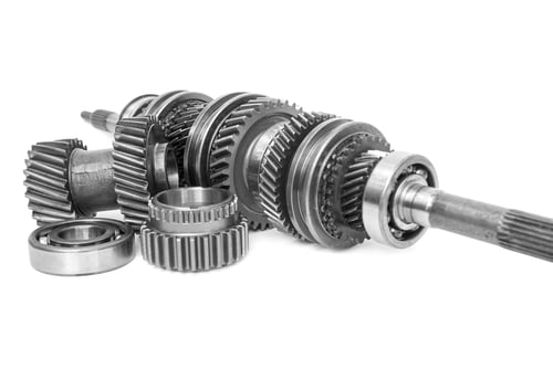 Automotive transmission gears laid out on a workbench.