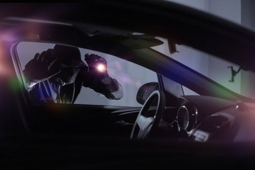 A black police car with flashing light.