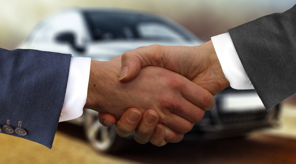 Two people in suits shaking hands, suggesting agreement or partnership.