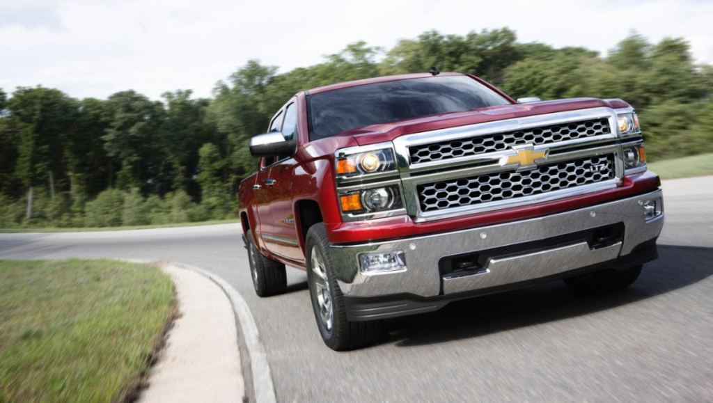 Red Chevrolet pickup truck parked on rocky desert terrain