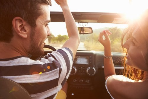 A man is driving a car and a girl sitting beside's sit.