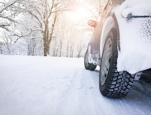 Car tire driving on snowy road.
