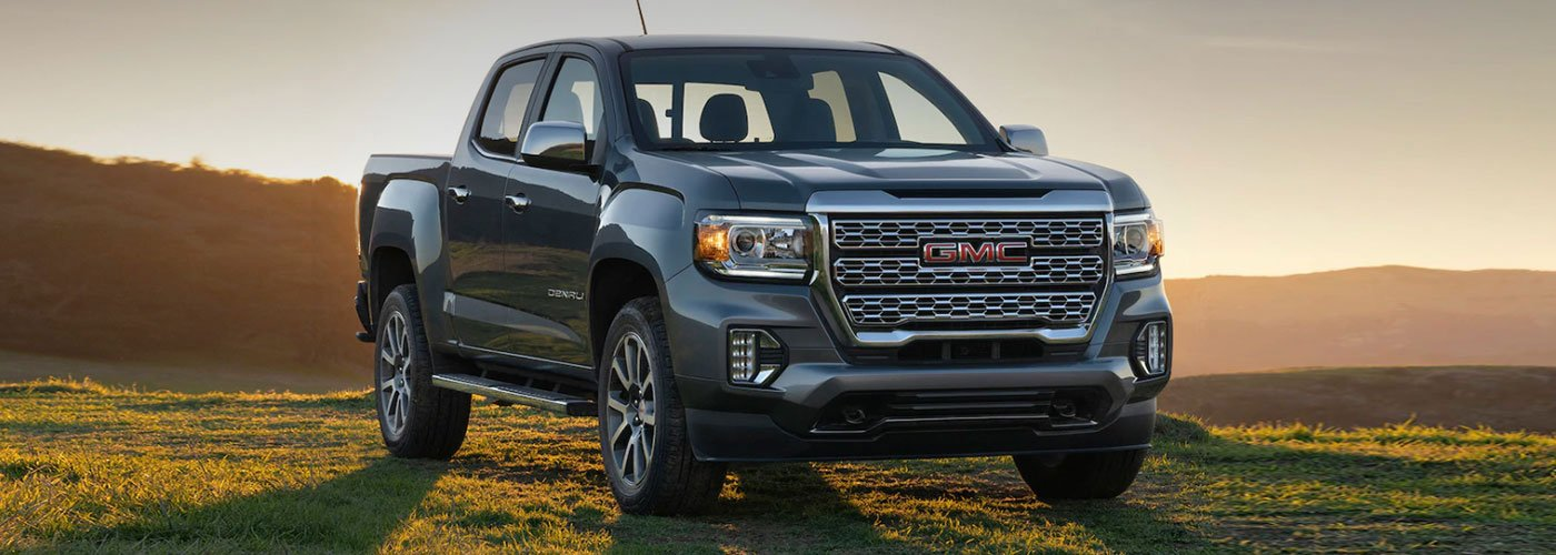 A black GMC Denali pickup truck with a large grille, red GMC logo, 