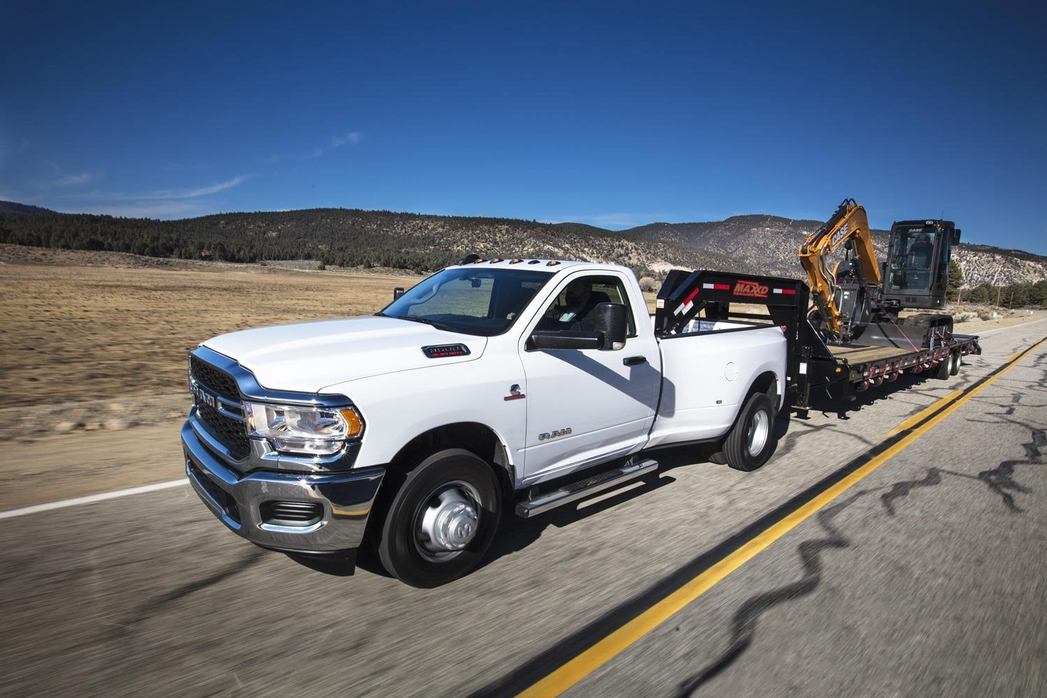 A Ram pickup truck towing a large trailer.