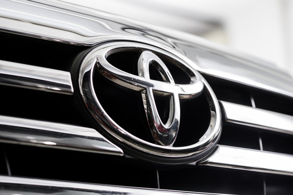 Close-up of the silver Toyota emblem on a black car grille.