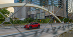 Gray 2024 Chevrolet Equinox EV driving on a city street.
