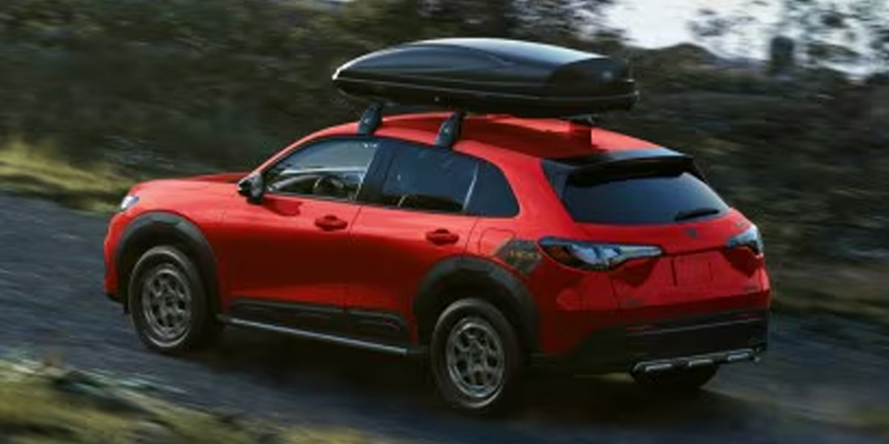 A 2026 Honda HR-C driving down a wooded road