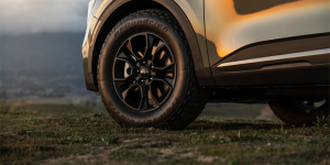 A 2025 Kia Sportage zoomed in to show just the front driver's side tire, parked outdoors at sunset near Orangeburg, SC