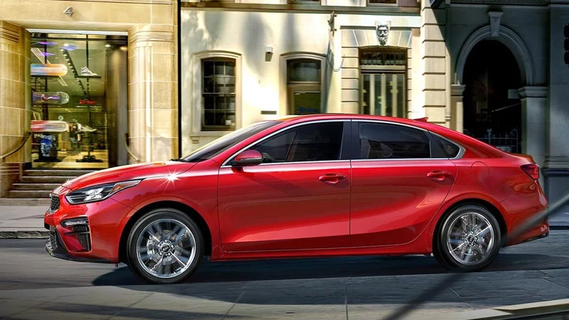 A red Kia Forte parked in front of 