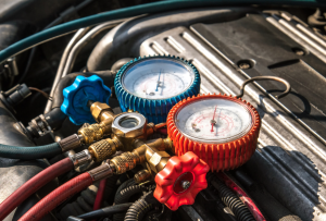 A red and a blue gauge that are part of a car's air conditioning system that's being worked on at a service center near Orangebug, South Carolina