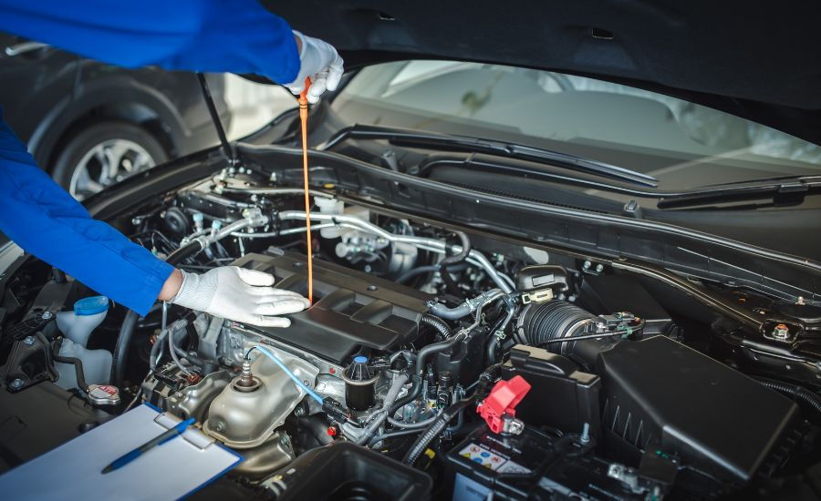 Hyundai service technician pouring new oil into a vehicle engine