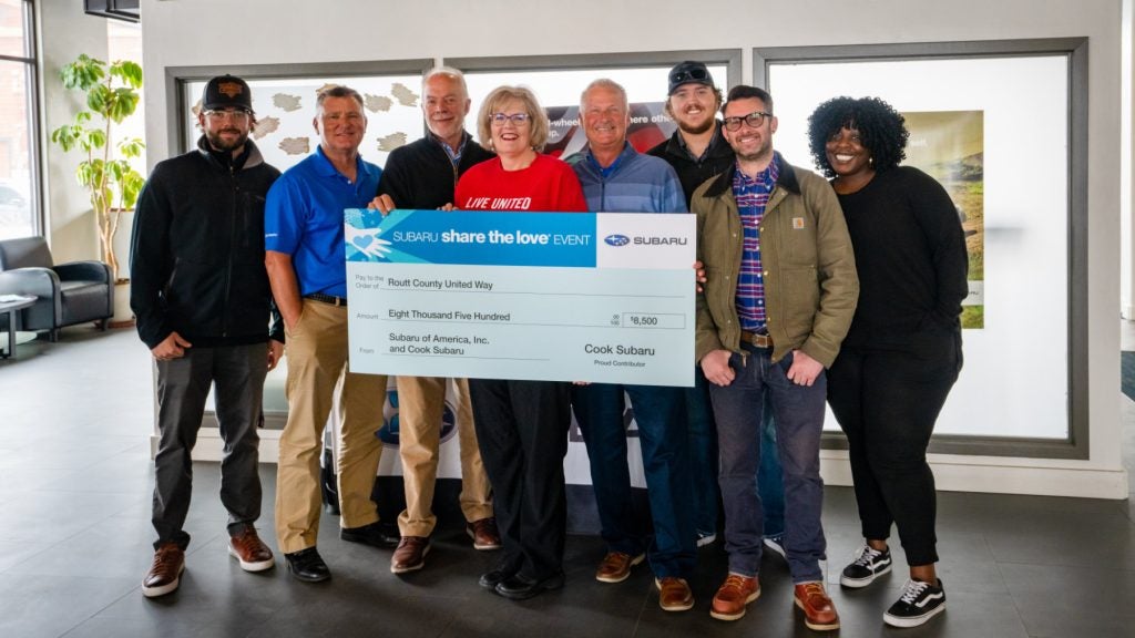 Eight people hold a large check for $8,500 from Subaru and Cook Subaru to Routt County United Way.