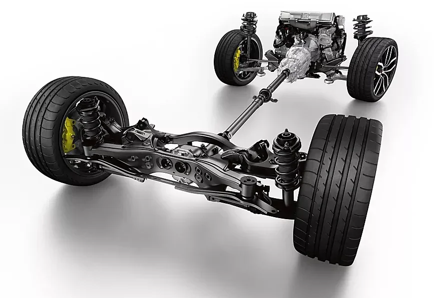 Full view of a car's exposed drivetrain, suspension, and wheels against a white background.