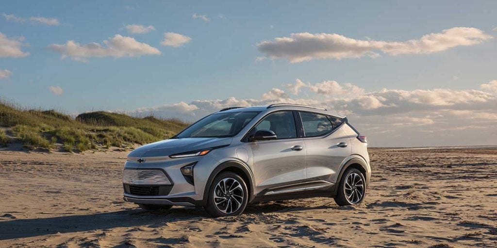 Chevy Bolt EUV Parked near sea on sand.