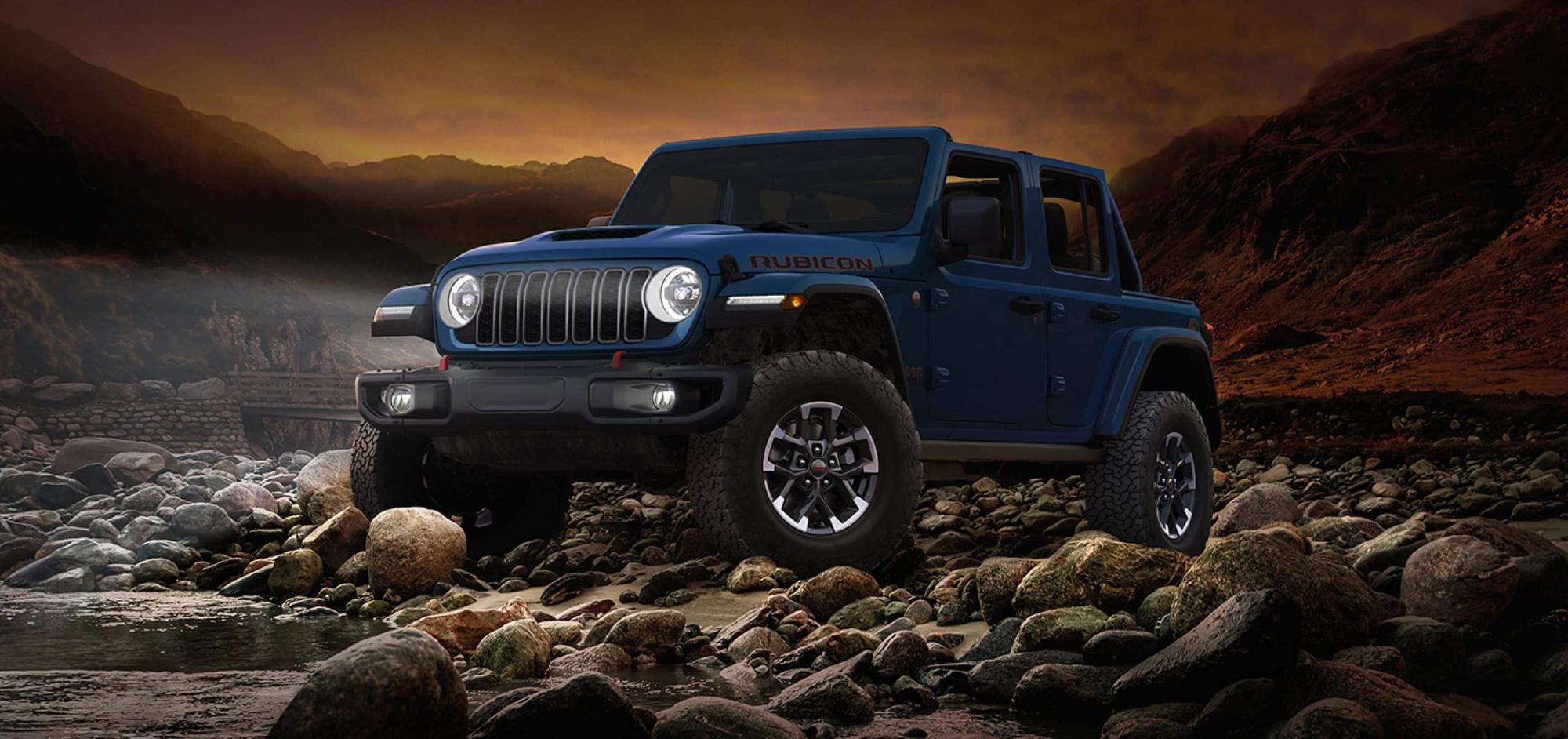 Blue 2026 Jeep Wrangler Rubicon X parked on a rocky shoreline, a Jeep Wrangler for Bowie, TX lake days