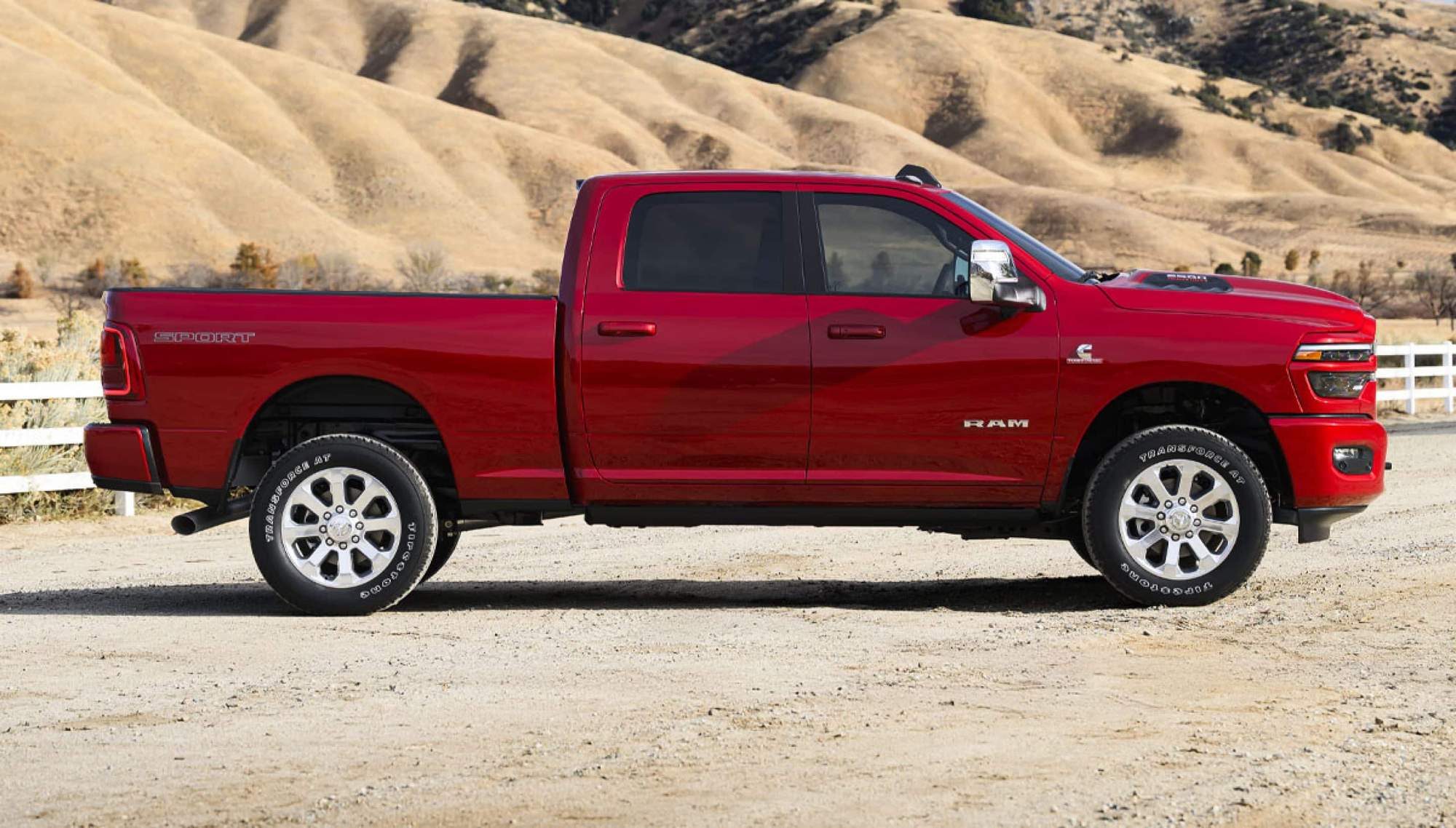 Red 2026 Ram 2500 Laramie crew cab on a dry ranch trail, the heavy duty step up from a Ram 1500 near Bowie, TX