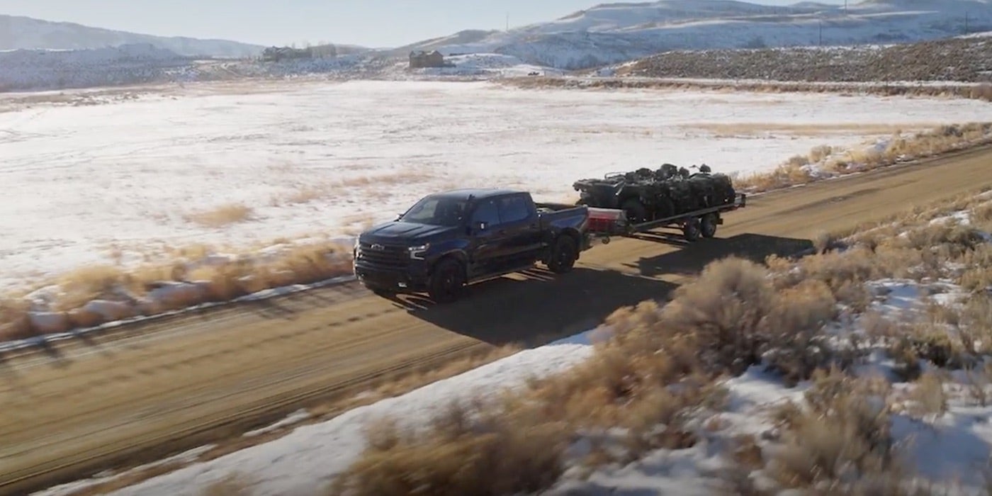 Chevrolet Silverado 1500 towing a trailer down the road, shown for Bowie, TX buyers comparing it with the Ford F-150