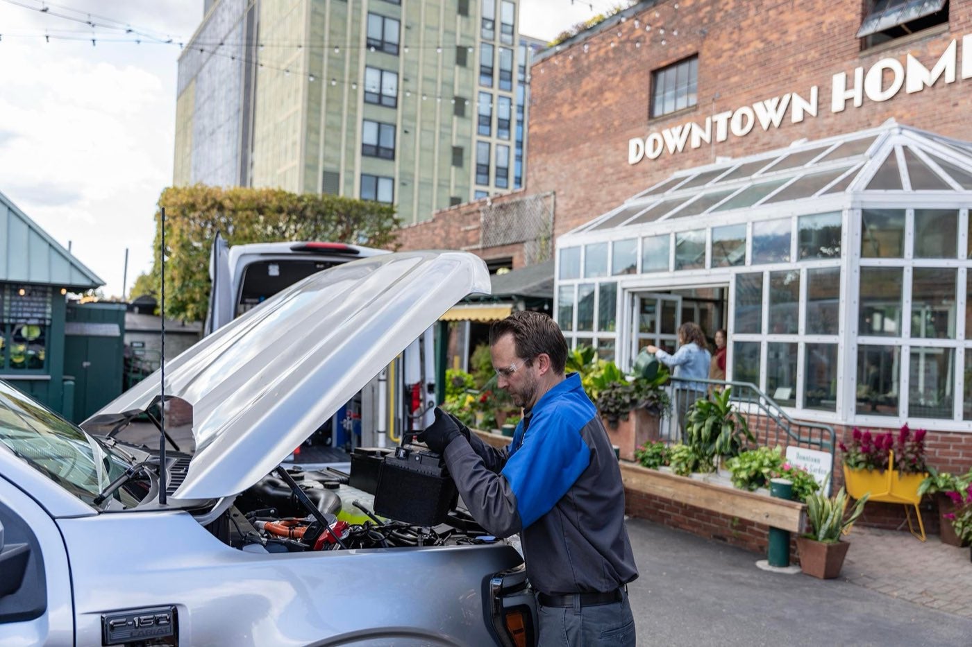 Ford technician replacing a battery under the hood of a vehicle, battery service for drivers around Bowie, TX