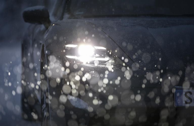 Headlights of a Porsche during rain