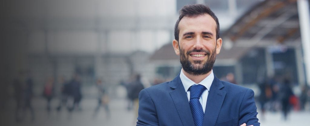Professional person in suit smiling with city background