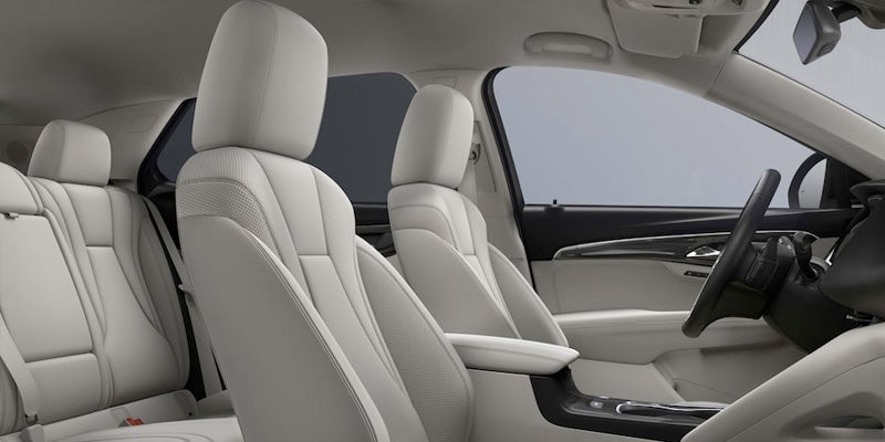 Modern car interior featuring light beige leather front and rear seats, a sleek center console