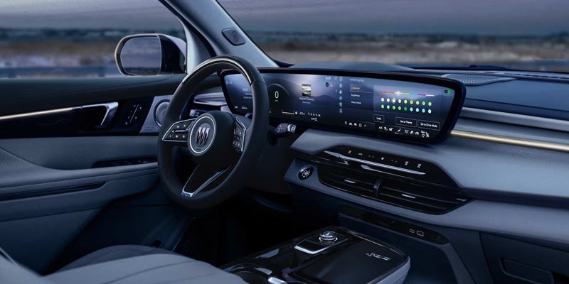 Interior view of a modern car dash and steering wheel, with a widescreen digital display showing ambient lighting options.