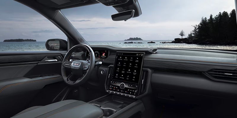 Modern GMC SUV interior featuring a large vertical touchscreen infotainment system and steering wheel