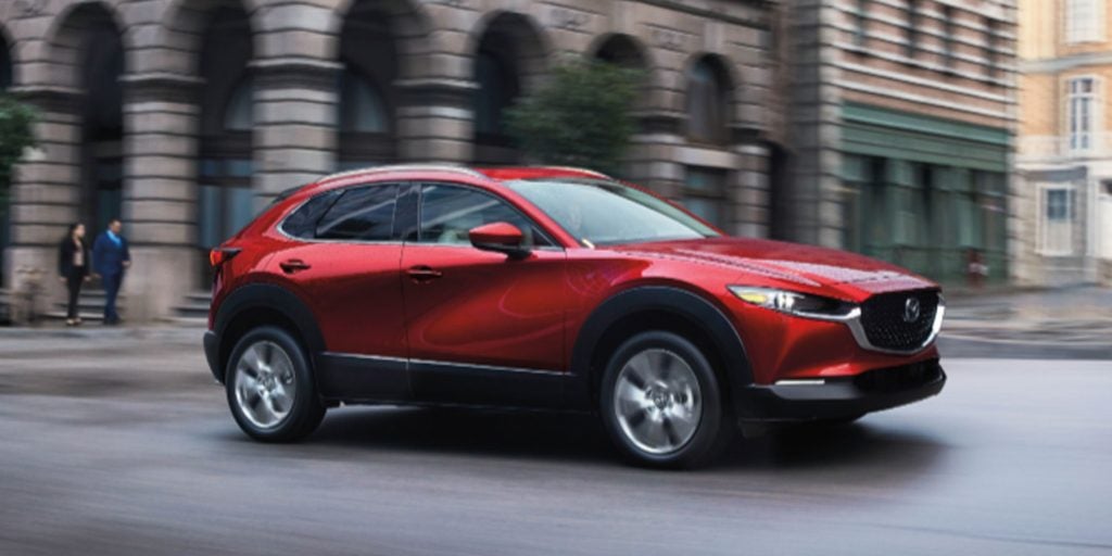A red Mazda CX- 30 moving on city road.