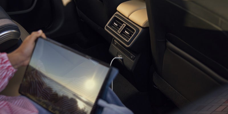 Rear passenger area with USB charging ports and tablet connectivity.