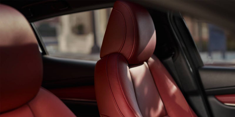 Close-up of a red leather-trimmed front seat inside a Mazda vehicle, highlighting the premium upholstery, contoured seat design