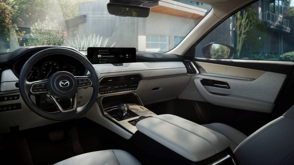 Front cabin of a modern SUV featuring a multifunction steering wheel, digital instrument cluster, center-mounted infotainment display