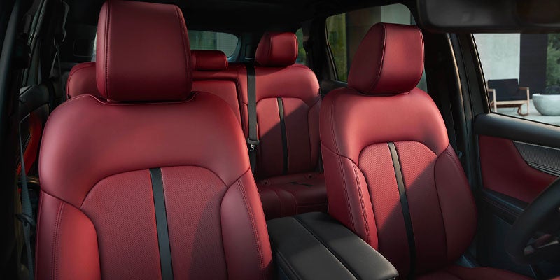 Mazda CX-series SUV showcasing a bold black front grille and a luxury interior with red Nappa leather seats and three-row seating.