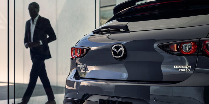 Close-up rear view of a Mazda3 hatchback featuring distinctive LED taillights, Mazda emblem, and Skyactiv-G Turbo badging
