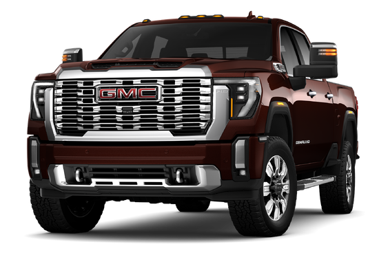 A gray 2024 GMC Sierra 2500HD Denali pickup truck with a large chrome grille in a desert with mountains.