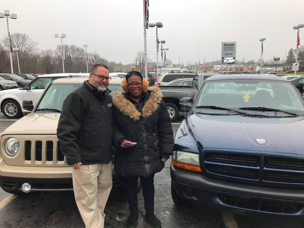 Customer and Cueter salesperson standing together on the dealership lot