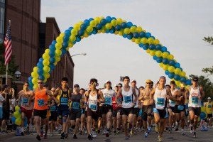 Runners at the start of the Ann Arbor Marathon under a balloon arch