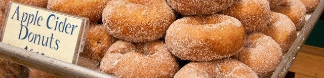 Apple cider donuts beside a hand-lettered sign