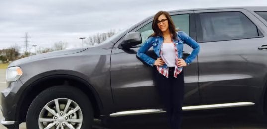 Woman standing beside a Dodge Durango