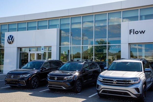 Three Volkswagen SUVs parked outside a Volkswagen dealership.