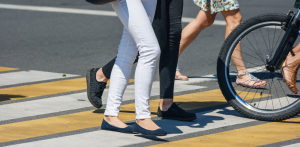 Pedestrians and cyclist crossing a street crosswalk, highlighting urban pedestrian safety and shared road use