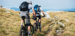 Two mountain bikers riding along a rugged trail, highlighting the risks of cycling and potential legal assistance from a bike accident lawyer