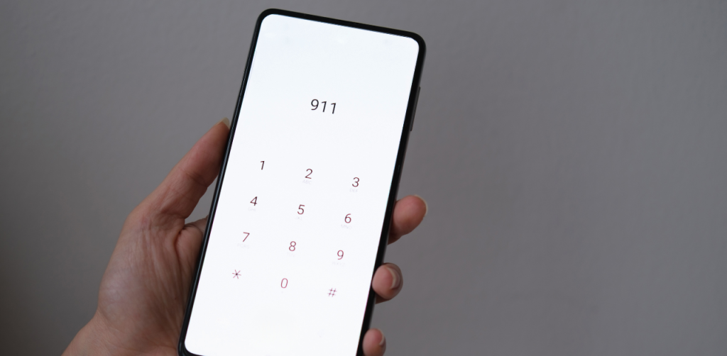 Hand holding a smartphone with 911 dialed on the screen, symbolizing emergency response after an Uber or Lyft accident in Las Vegas