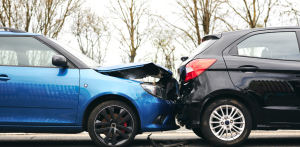 Two cars involved in a rear-end collision, with the blue car's front damaged and the black car's rear dented