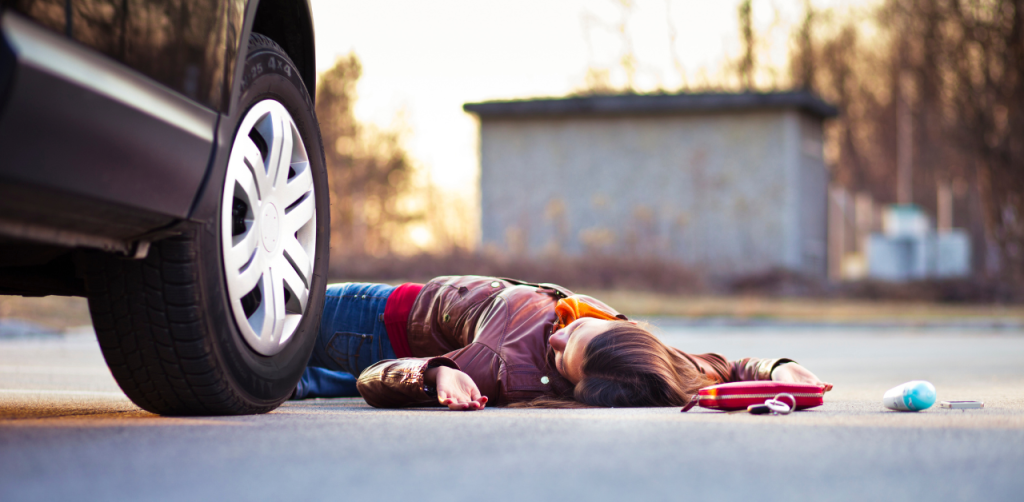 A woman got hit by a car and her wallet deodorant and keys are also lying down