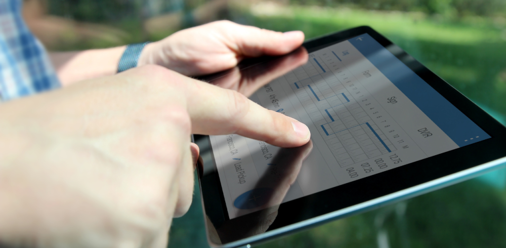 Person using a tablet to review a digital logbook with driving hours and schedules